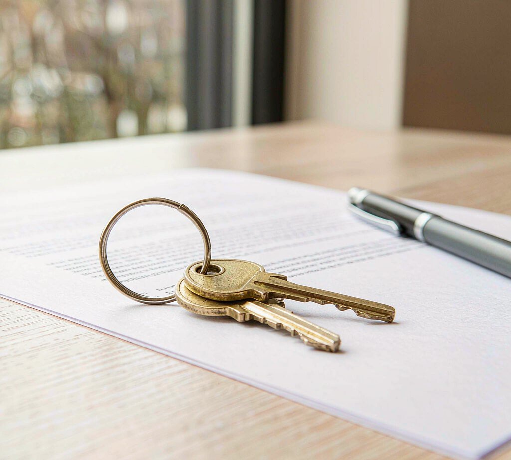 FAQ A set of door keys resting on a printed tenancy agreement